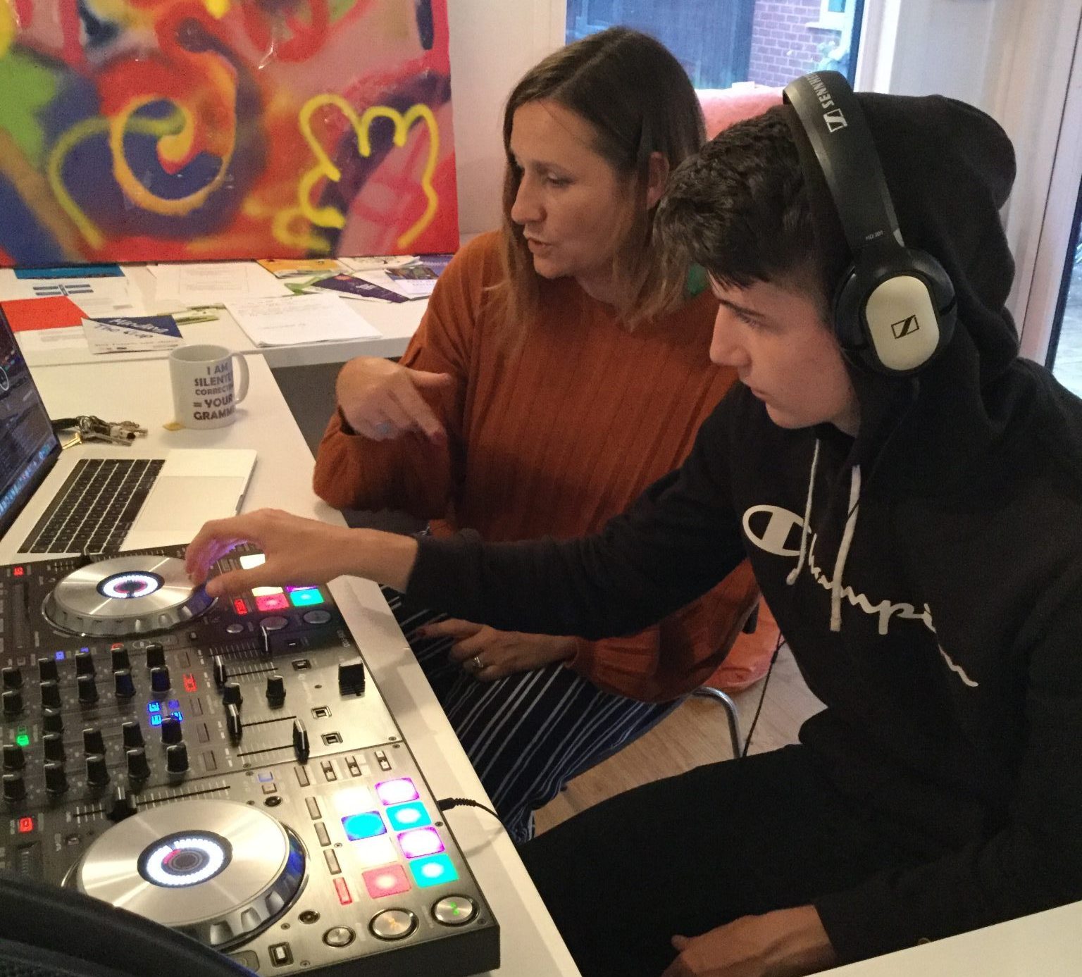 DJ tutor, Sophie, talking a young resident through mixing some tunes