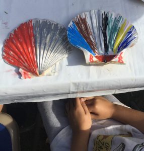 Two large scallop shells, one coloured red and silver and the other in bold coloured stripes