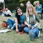 2 adults sitting on the grass