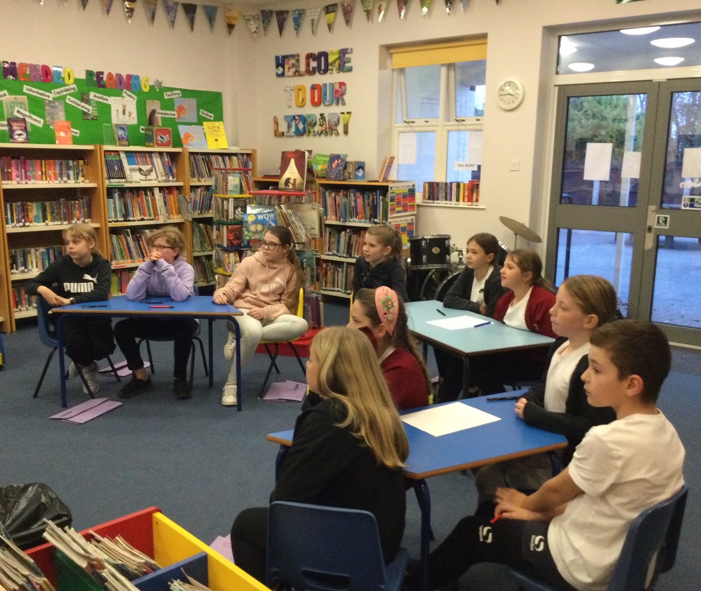 A group of school children seated in the library