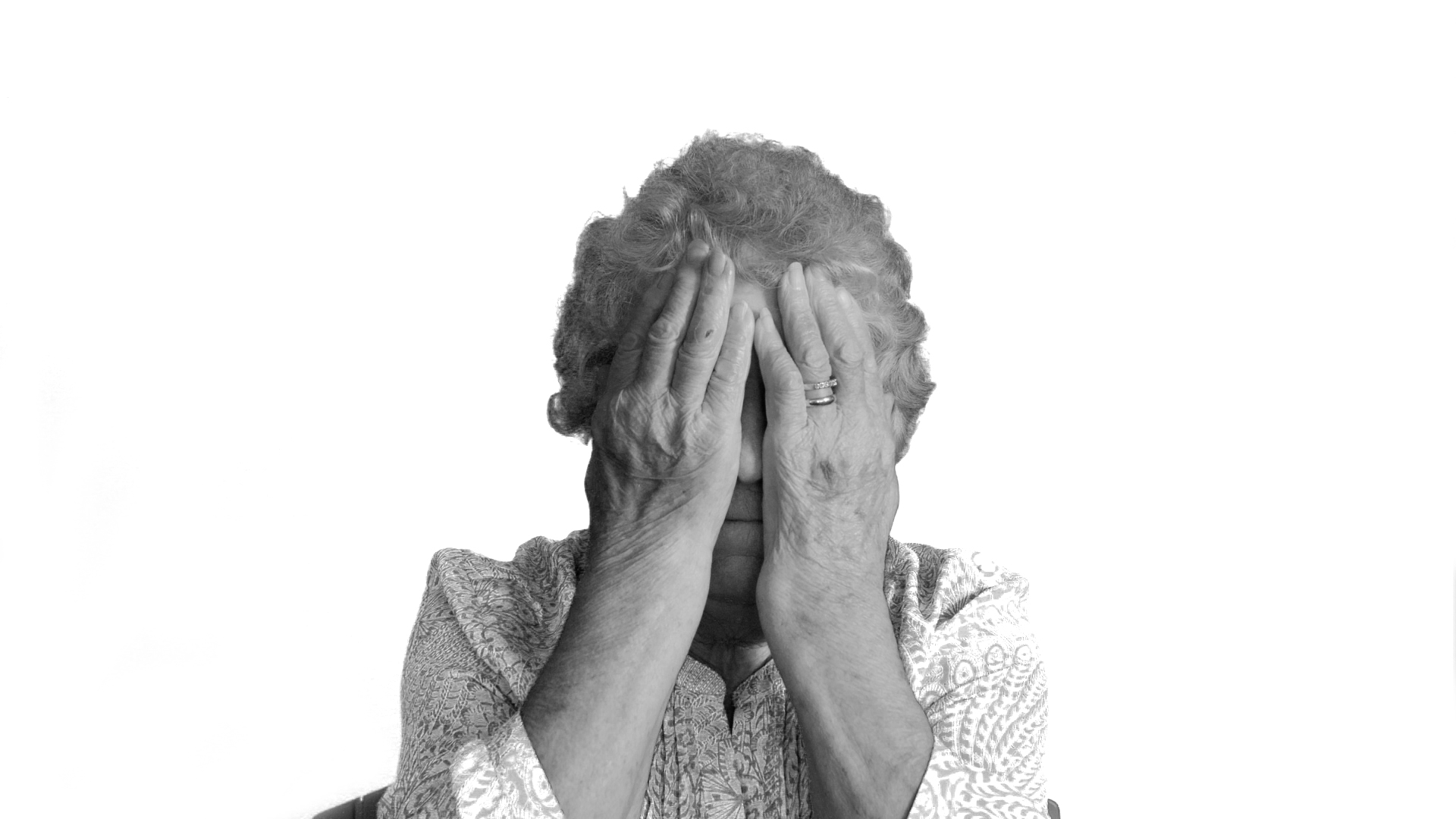 Monotone image of lady covering her face with her hands