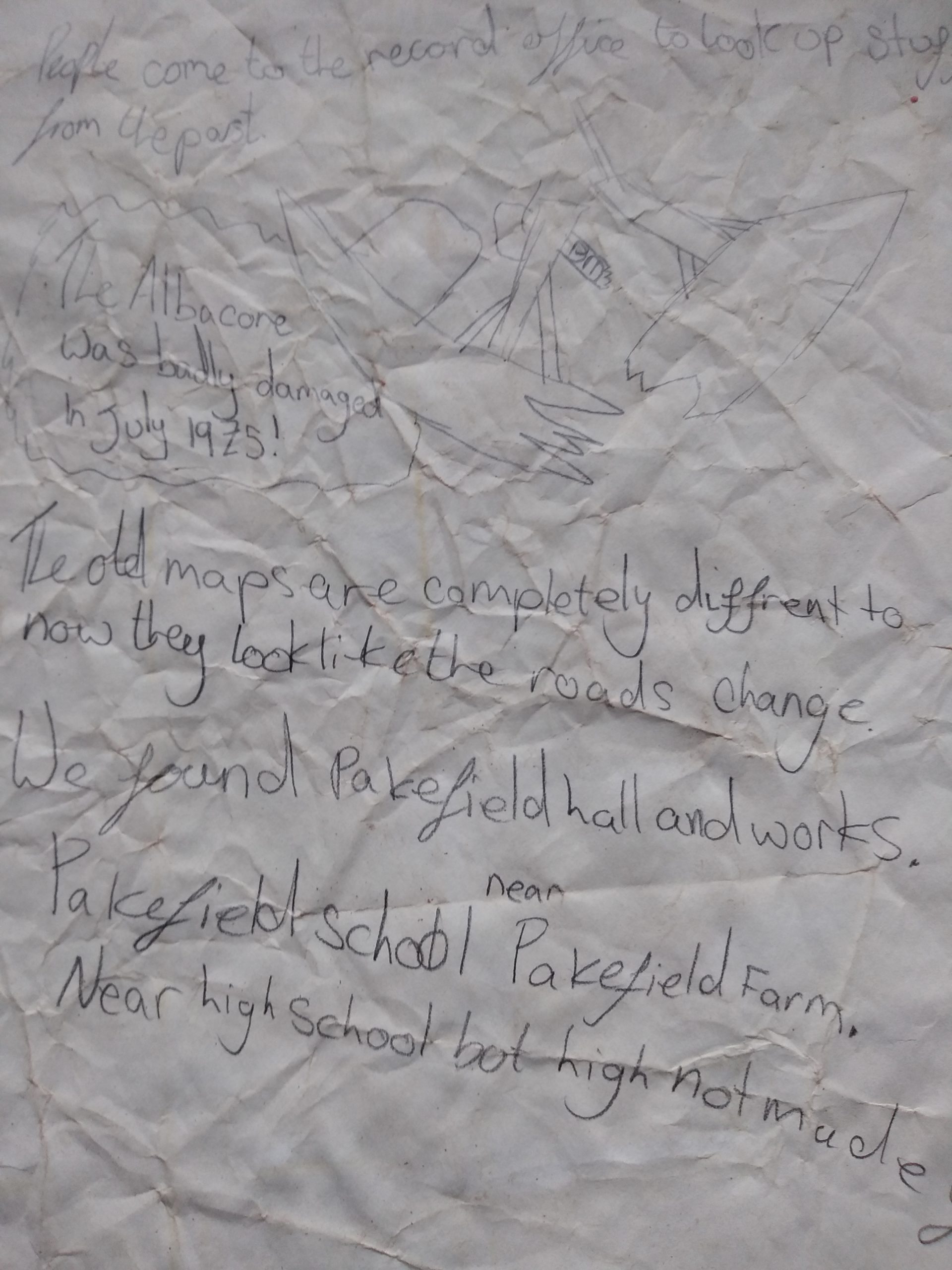A crumpled sheet of paper with pencil drawing and writing