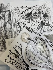 Prints made by our Woodbridge participants using natural materials, one print vividly depicting a bird surrounded by grass and flowers.