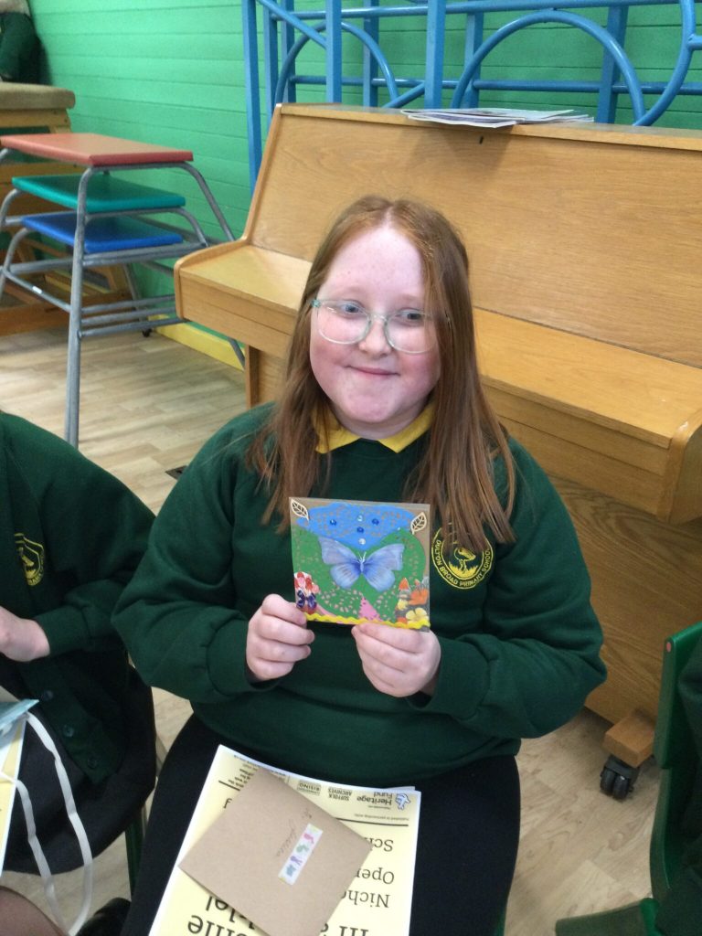 A child holding a card with a blue butterfly on it