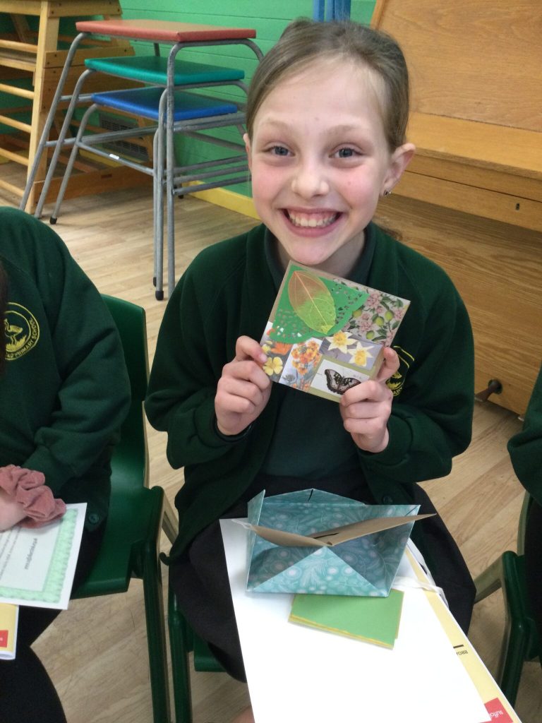 A beaming child holding up an Easter card