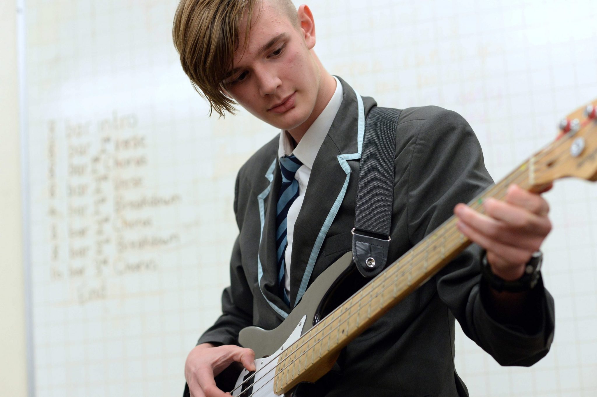 A young man plays bass guitar