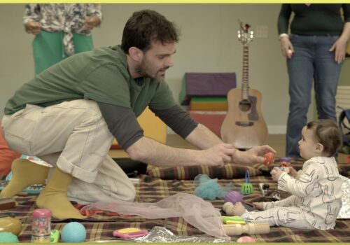 Musician showing shaky egg to baby