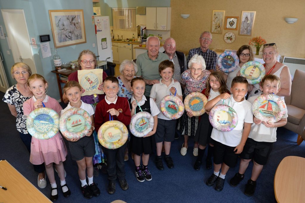 The Lowestoft Folk participants holding the embroidered pictures they made together