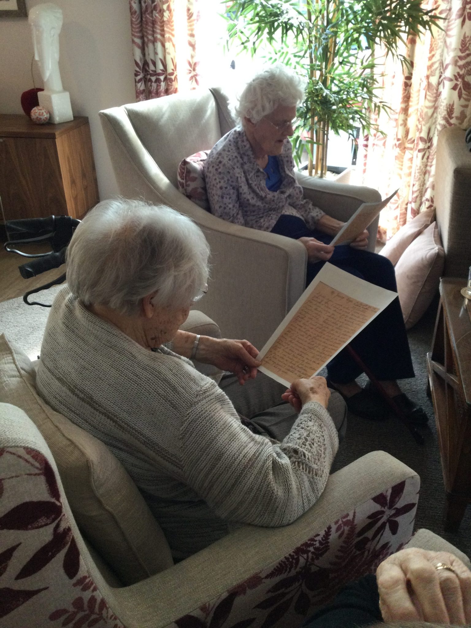 Two residents reading copies of a handwritten letter