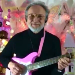Tom playing pink guitar