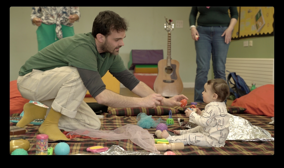 Musician showing shaky egg to baby