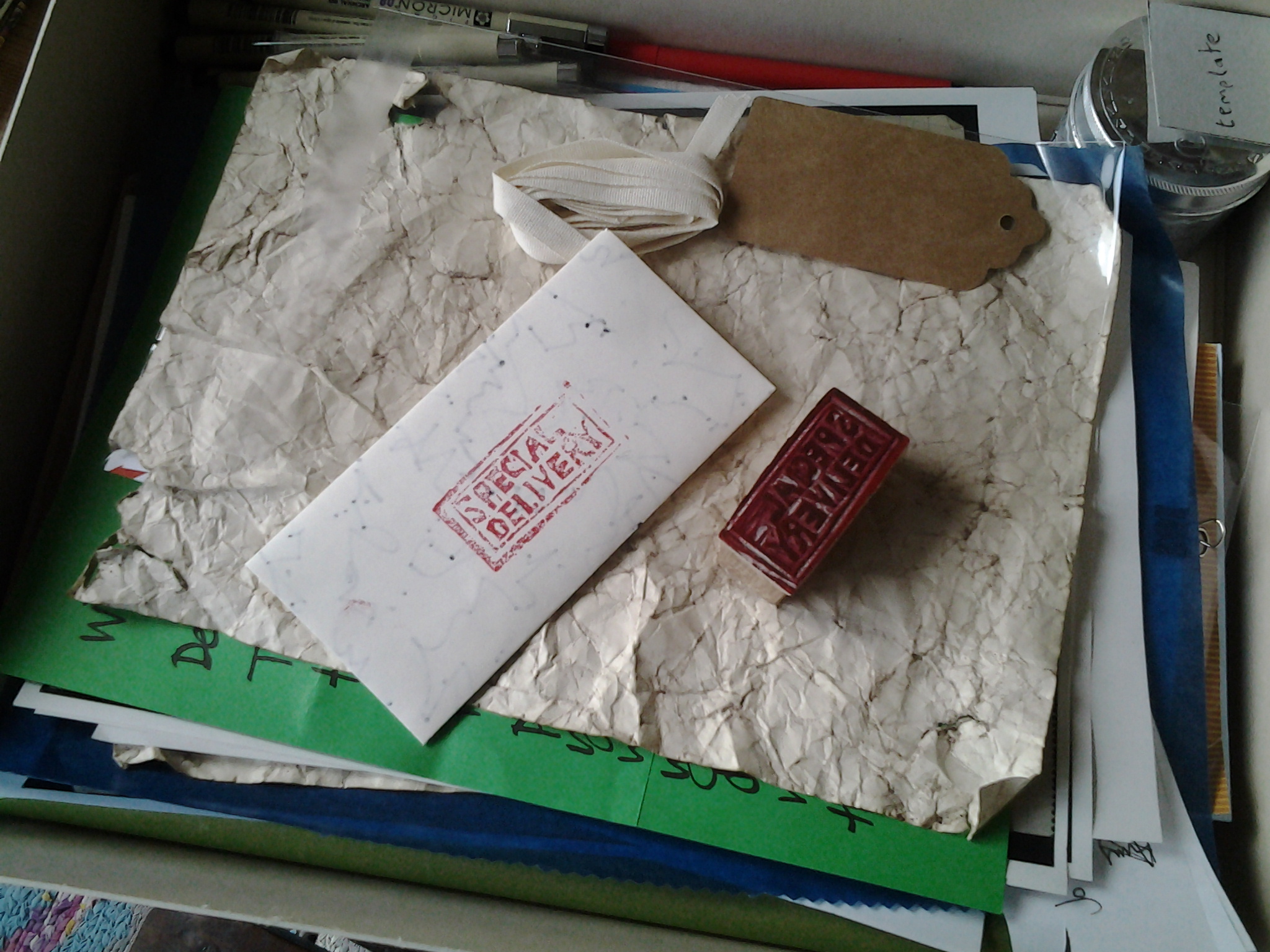 A pile of sheets of paper inside a box with an envelope stamped Special Delivery on the top