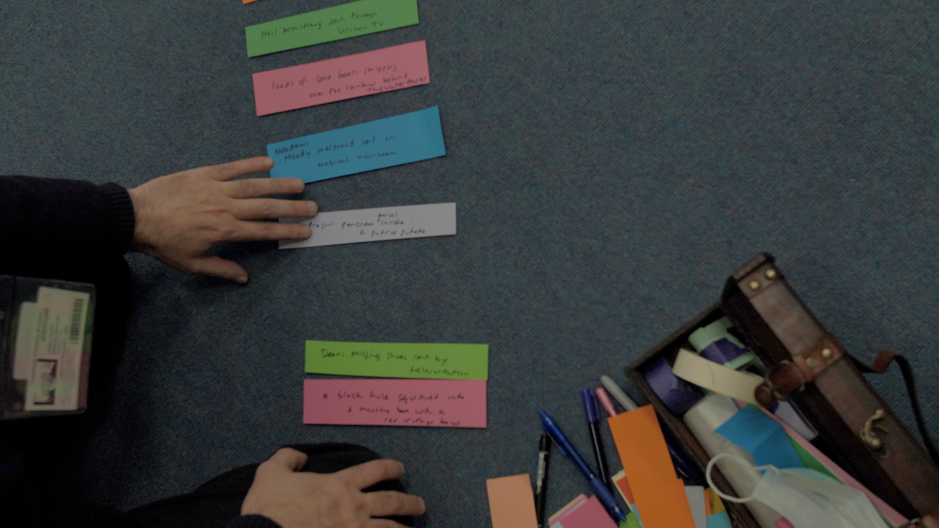 Coloured handwritten strips of paper being arranged to create a poem