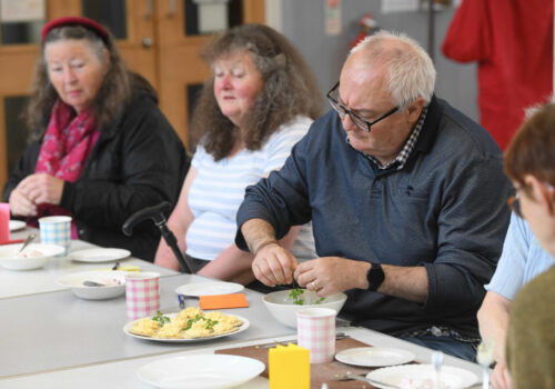 Four people sitting around a table creating a meal