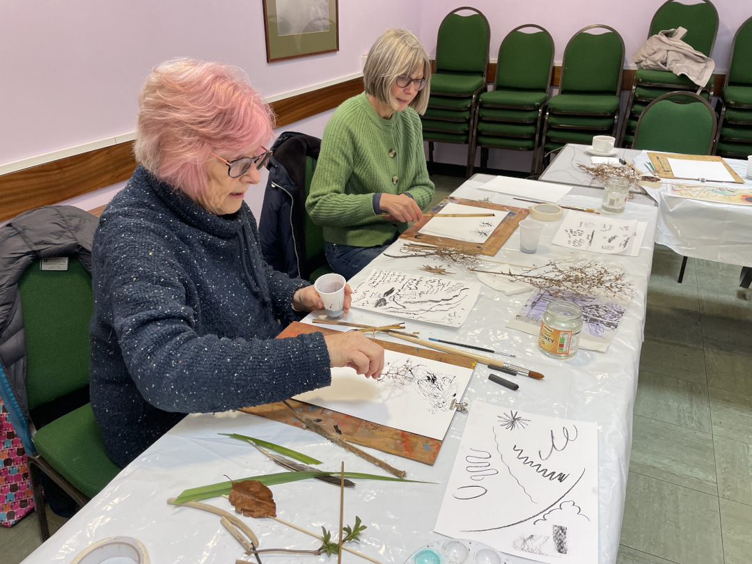 two people creating art with foraged plants