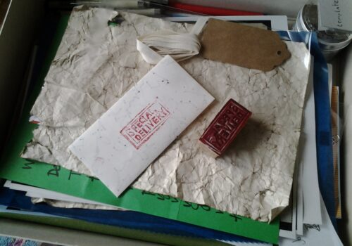 Envelope and Special Delivery stamp on top of pile of papers and stationery