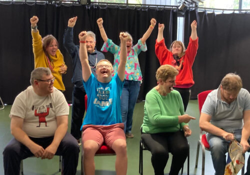 Brave Art students seated and standing with arms outstretched