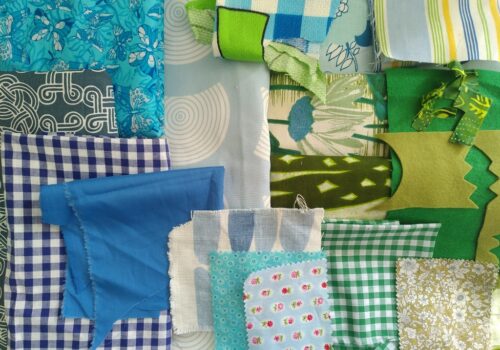 A selection of 18 fabrics in different shades and patterns of blue and green