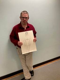 Artist, Erik James Mack, holding an artwork, pen and ink