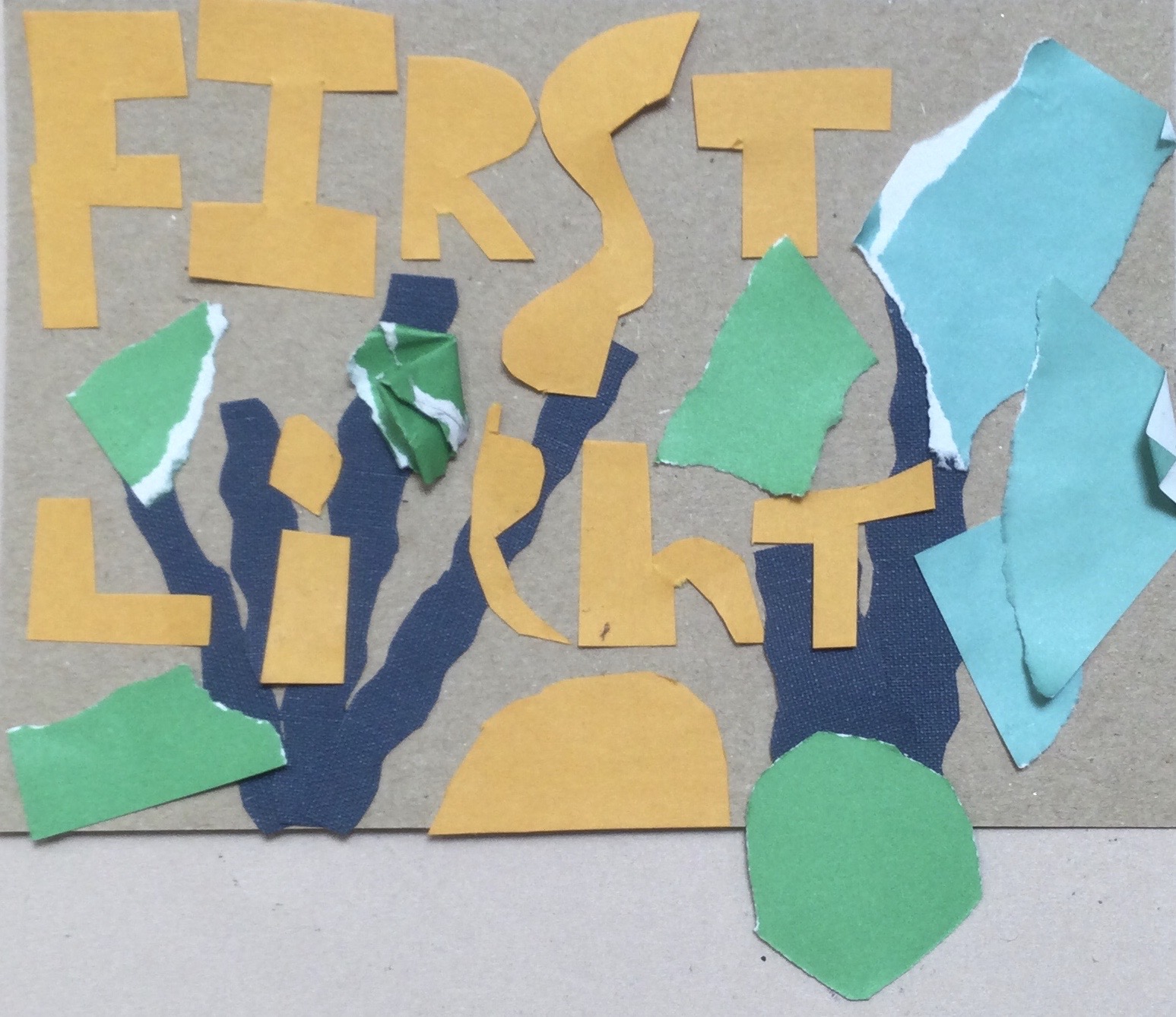 A plain brown postcard with cut out letters in sand-coloured paper spelling the words FIRST LIGHT over blue and green paper shapes