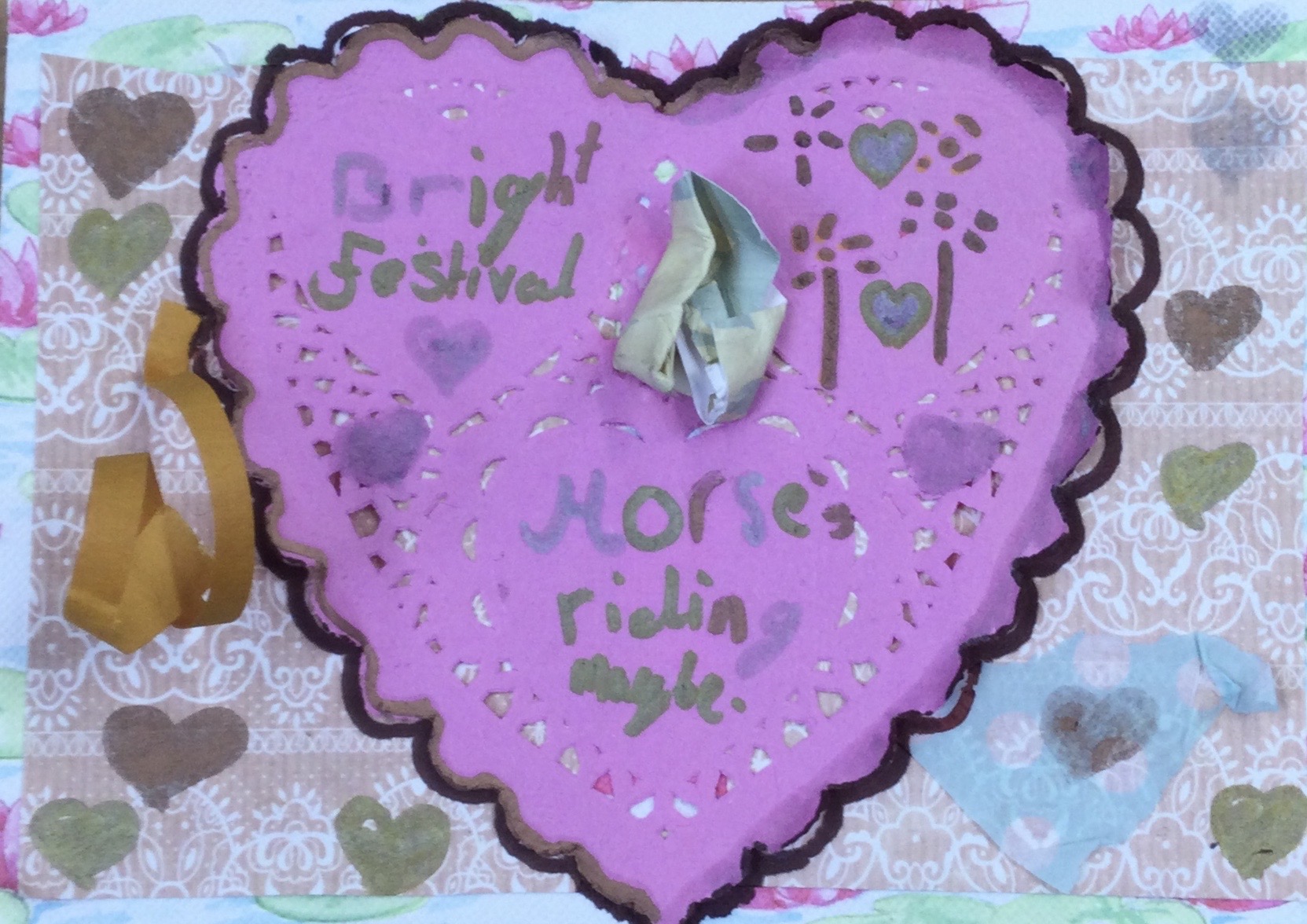 A large pink heart bearing the words Bright Festival and Horse riding maybe fills the centre of the card and is surrounded by smaller, hand-drawn hearts and embellishments of tape and scrumpled paper
