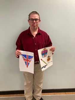 Artist, Erik James Mack, holding two coronation 2023, artworks