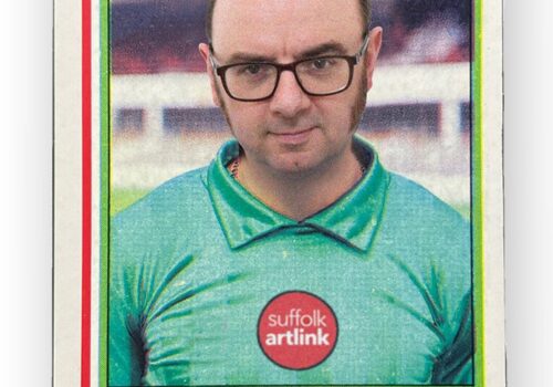 A face of a man, wearing spectacles and a green jersey with the words Suffolk Artlink in red on the chest. Above the image reads Extra Time and below the name of the individual