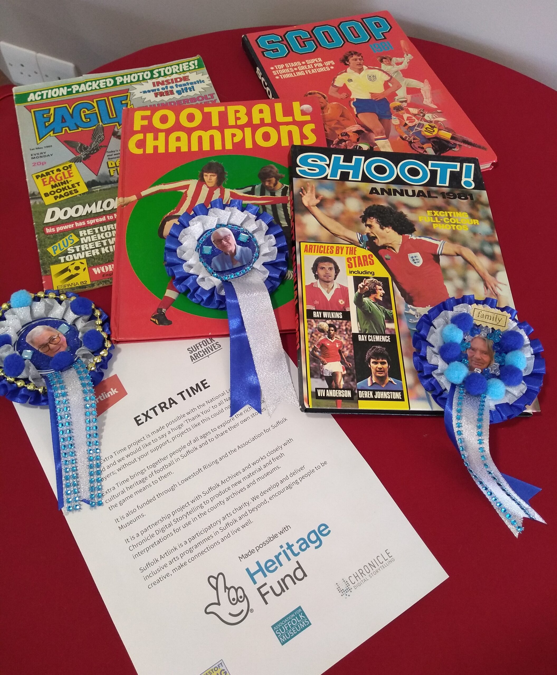A collection of hold football annuals and comics, with personalised football rosettes and information about the Extra Time project with thanks to the National Lottery Heritage Fund