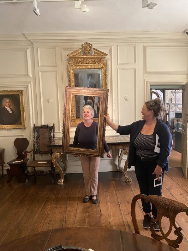 A Brave Art student poses behind a portrait frame