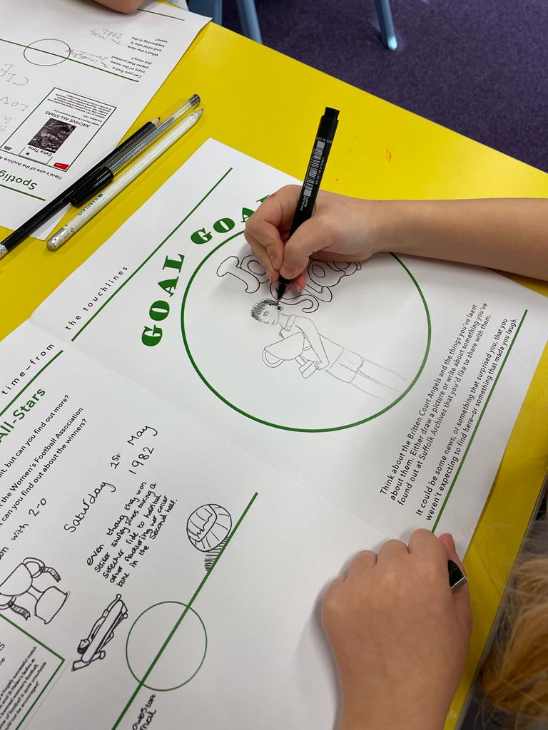 A child's hand, holding a pencil and drawing inside a green circle on a white sheet of paper