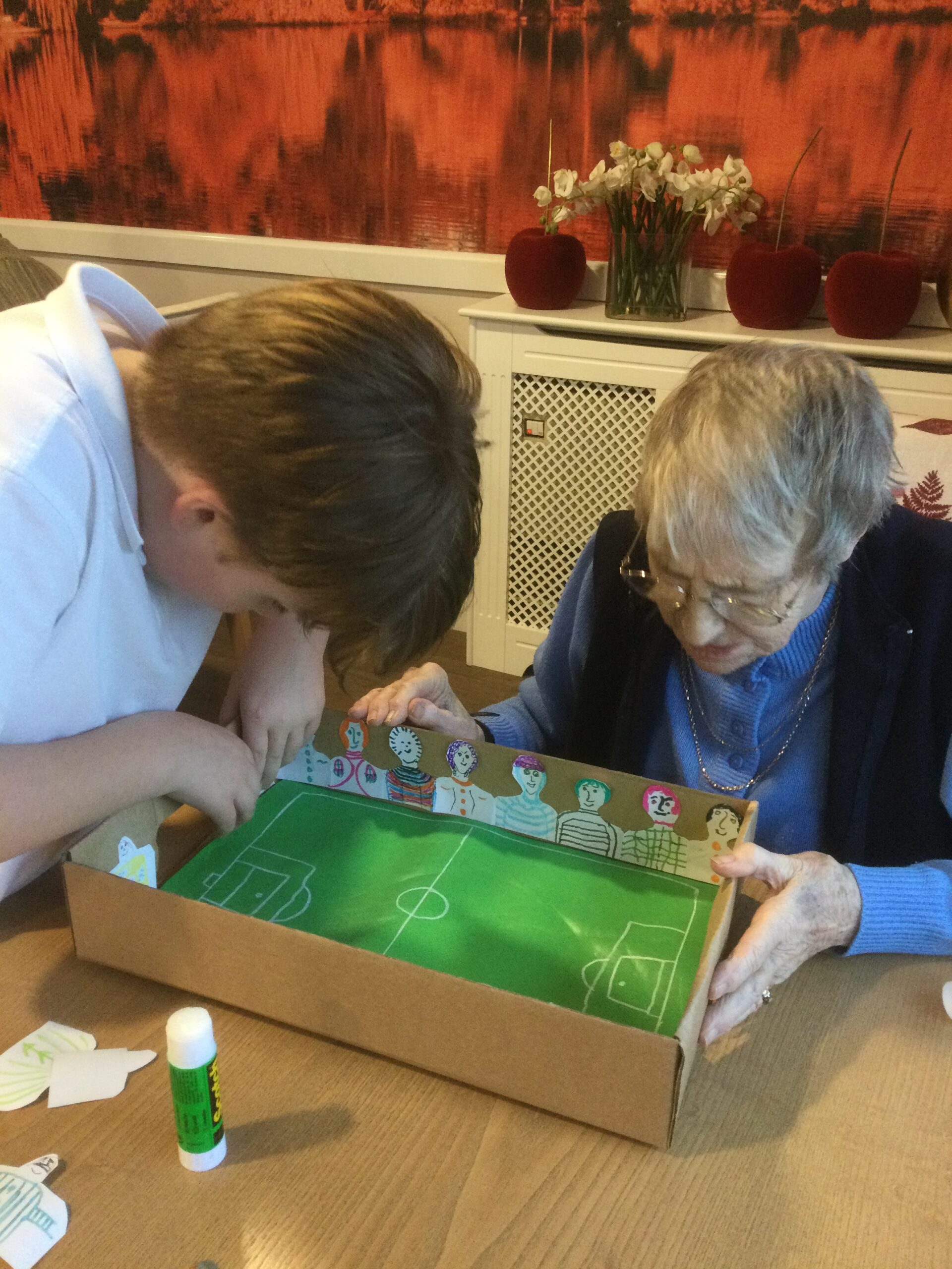 A woman and young lad working together to create a handmade football game