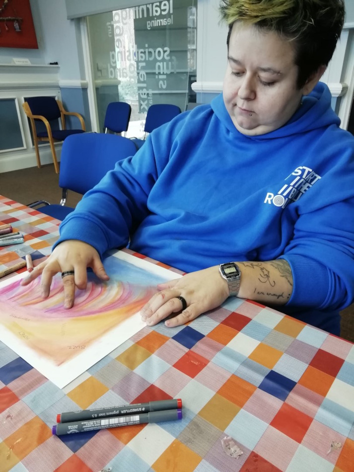 A woman seated at a table painting