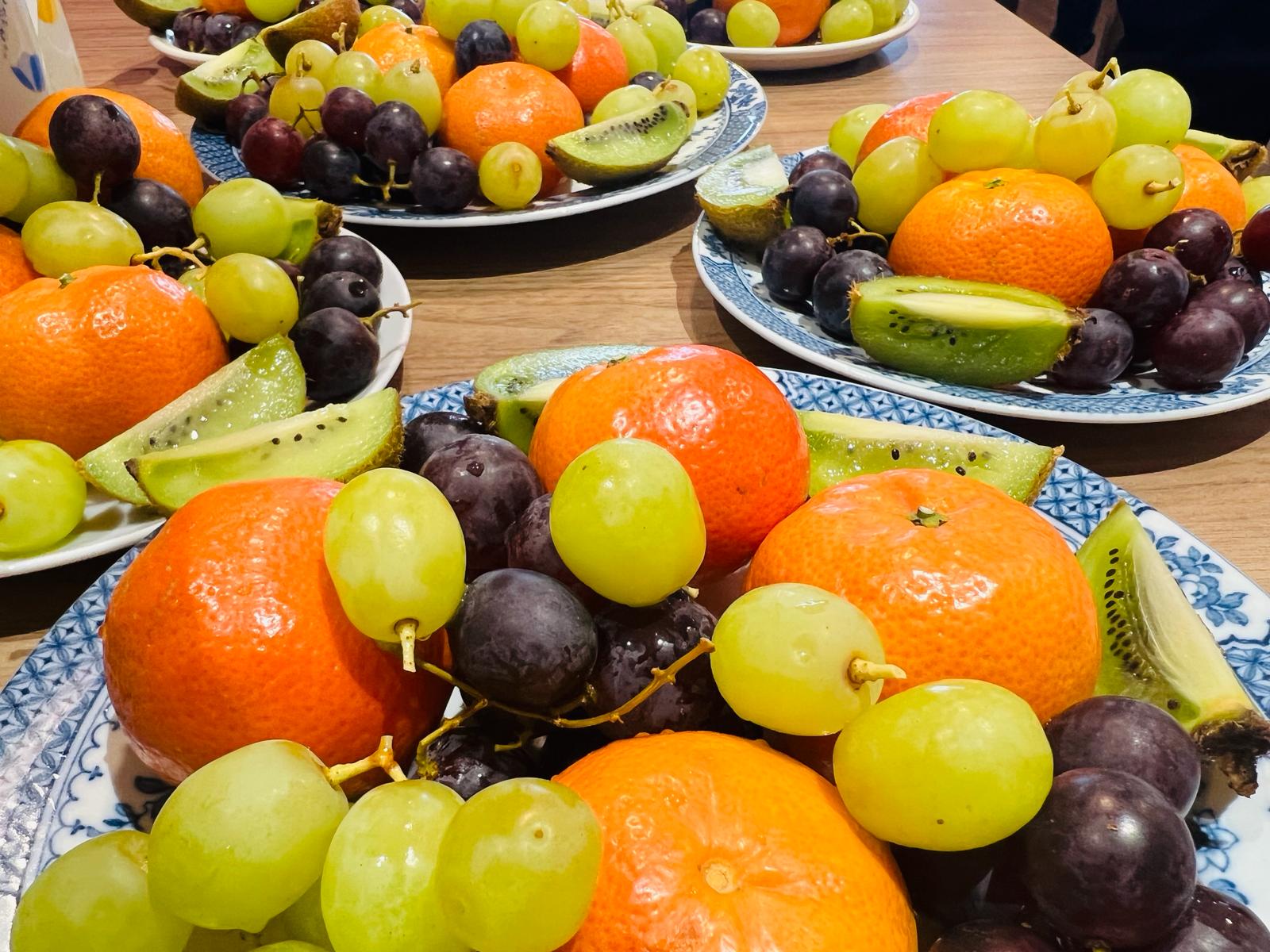 Plates of grapes, clementines and kiwi fruit