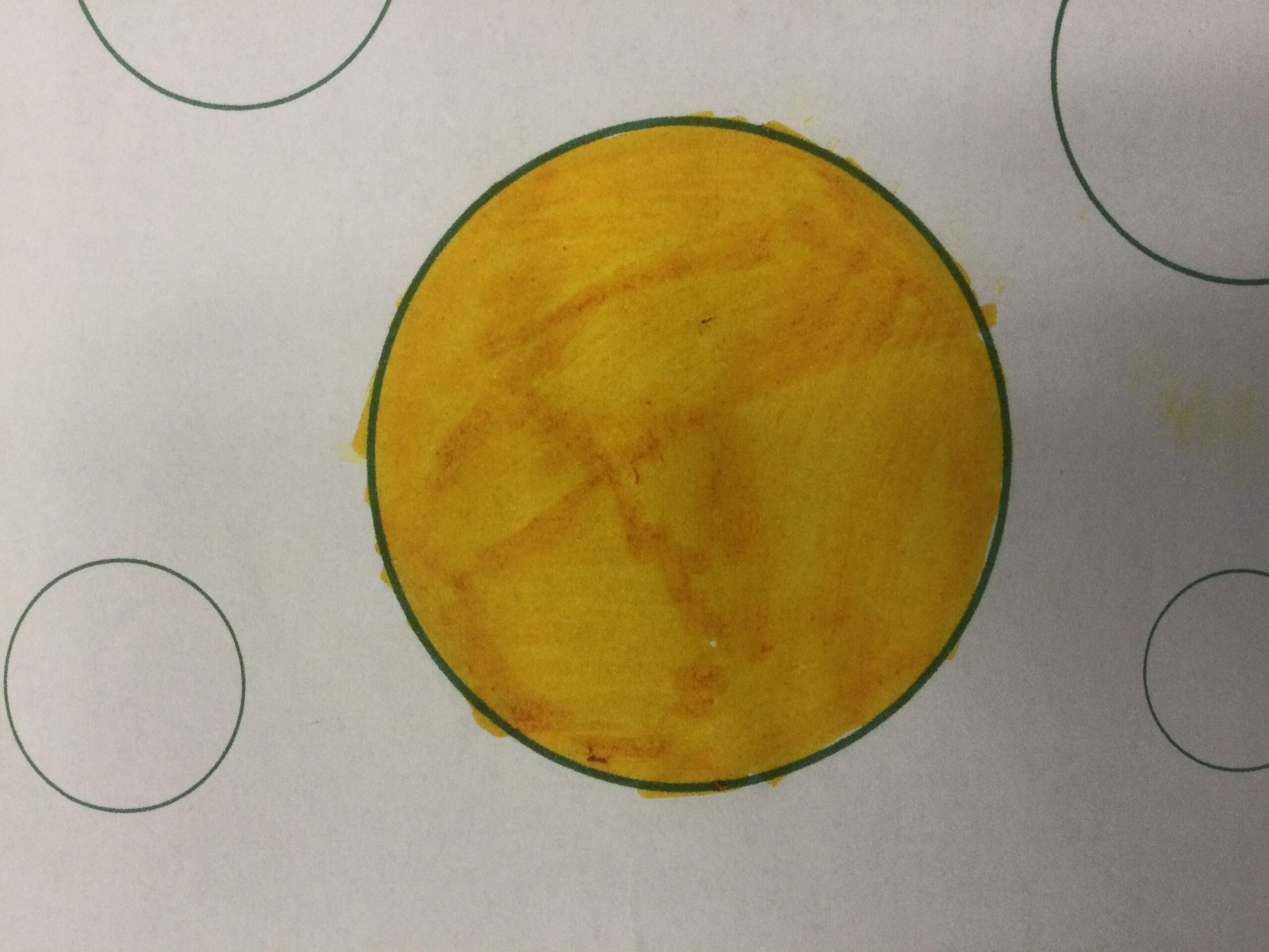 A gold coloured disc with a green outline