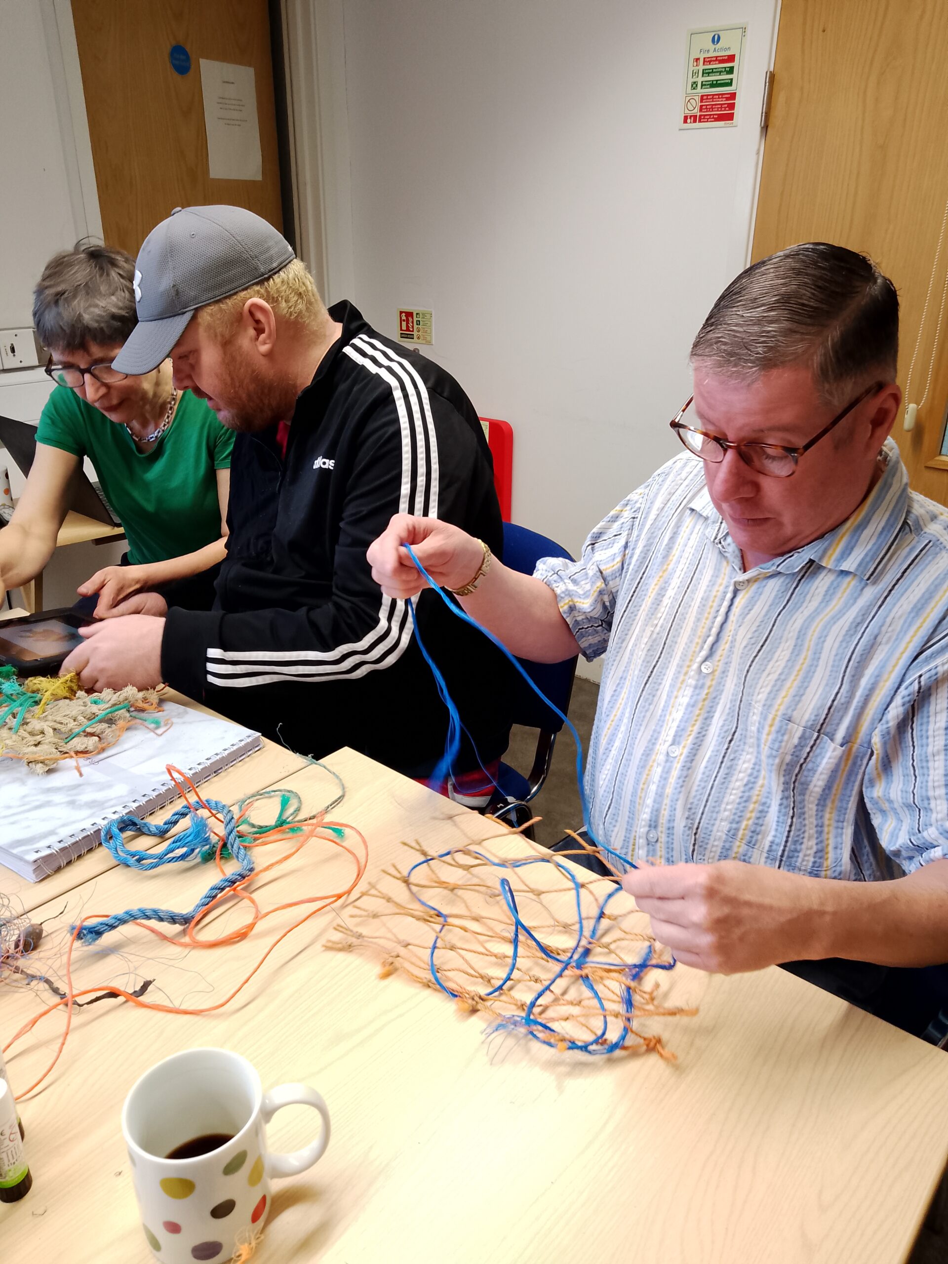 3 people making model fishing nets