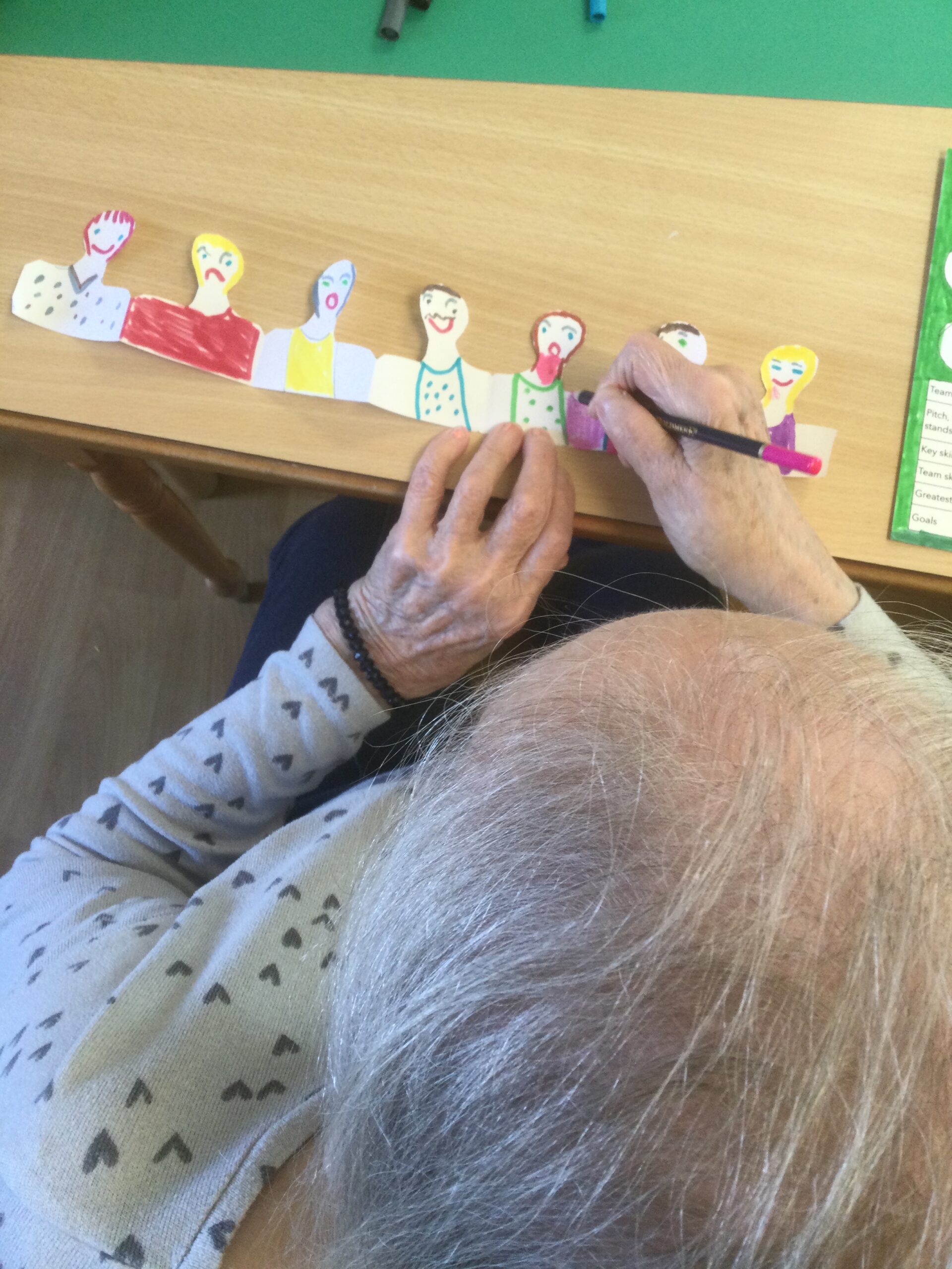 Overhead shot of person colouring in a row of faces
