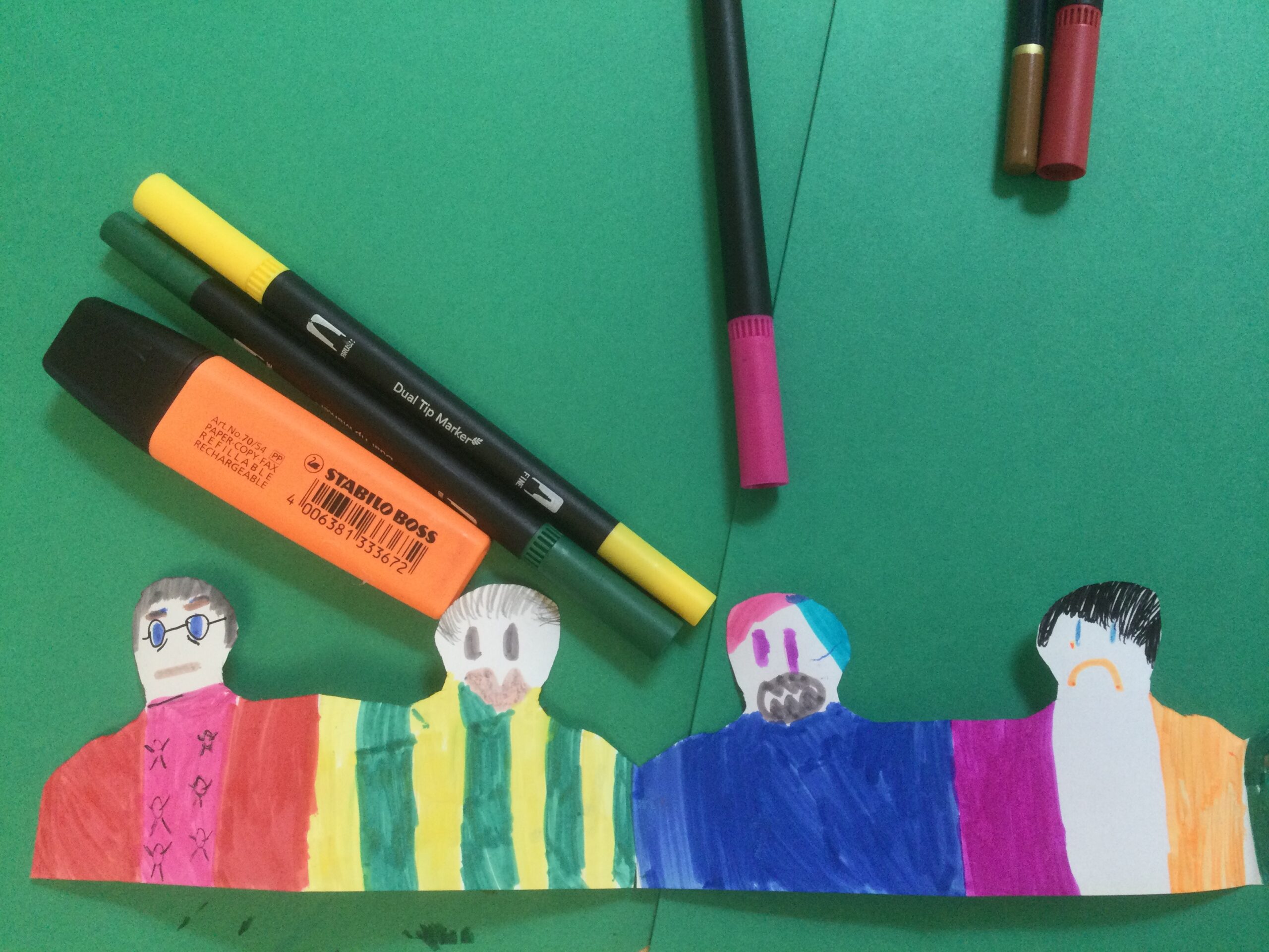 Four paper football fans coloured in with pencil and felt tip pen