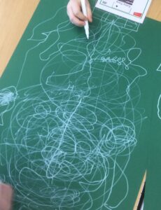 Pen football - white squiggles all over a large sheet of green paper