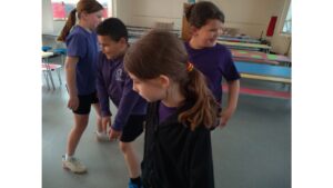 Four children caught on camera as they move around a school hall