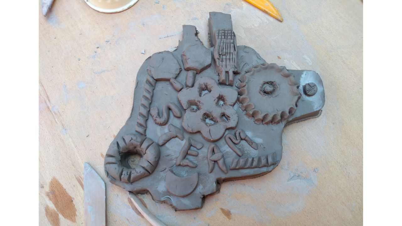 A clay slab with pieces added