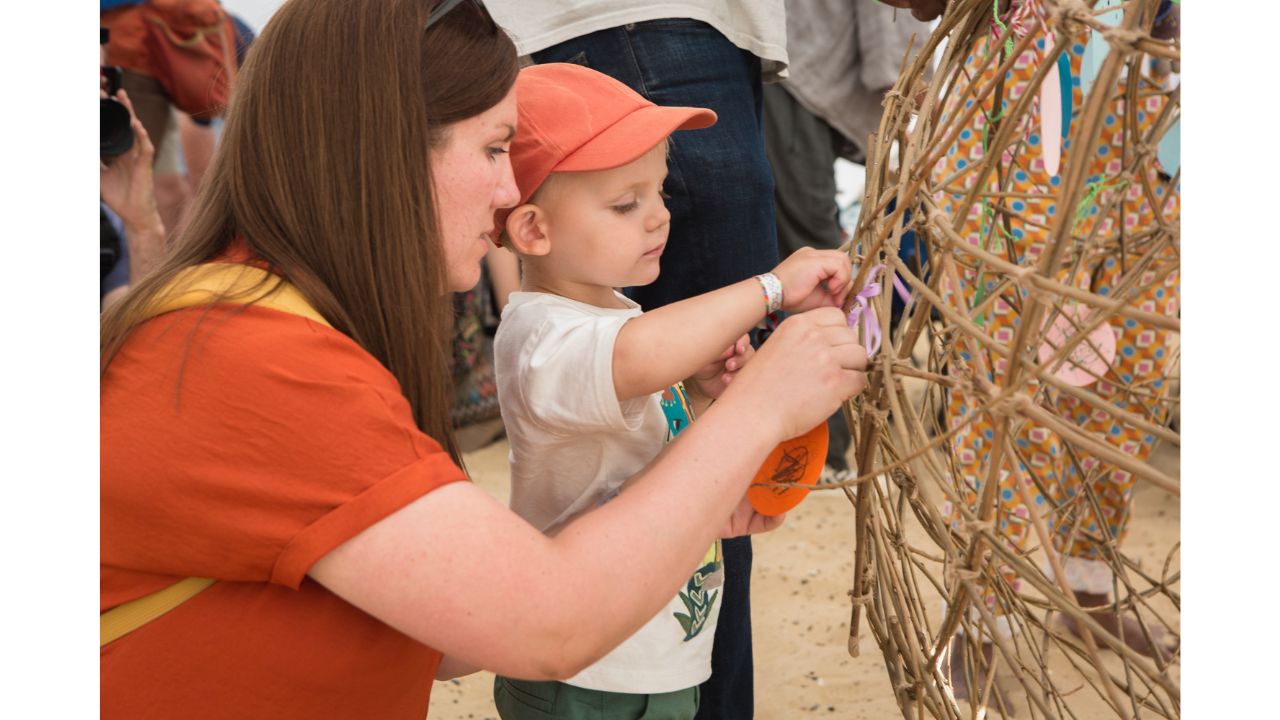 Mother and child tie something to a willow ball