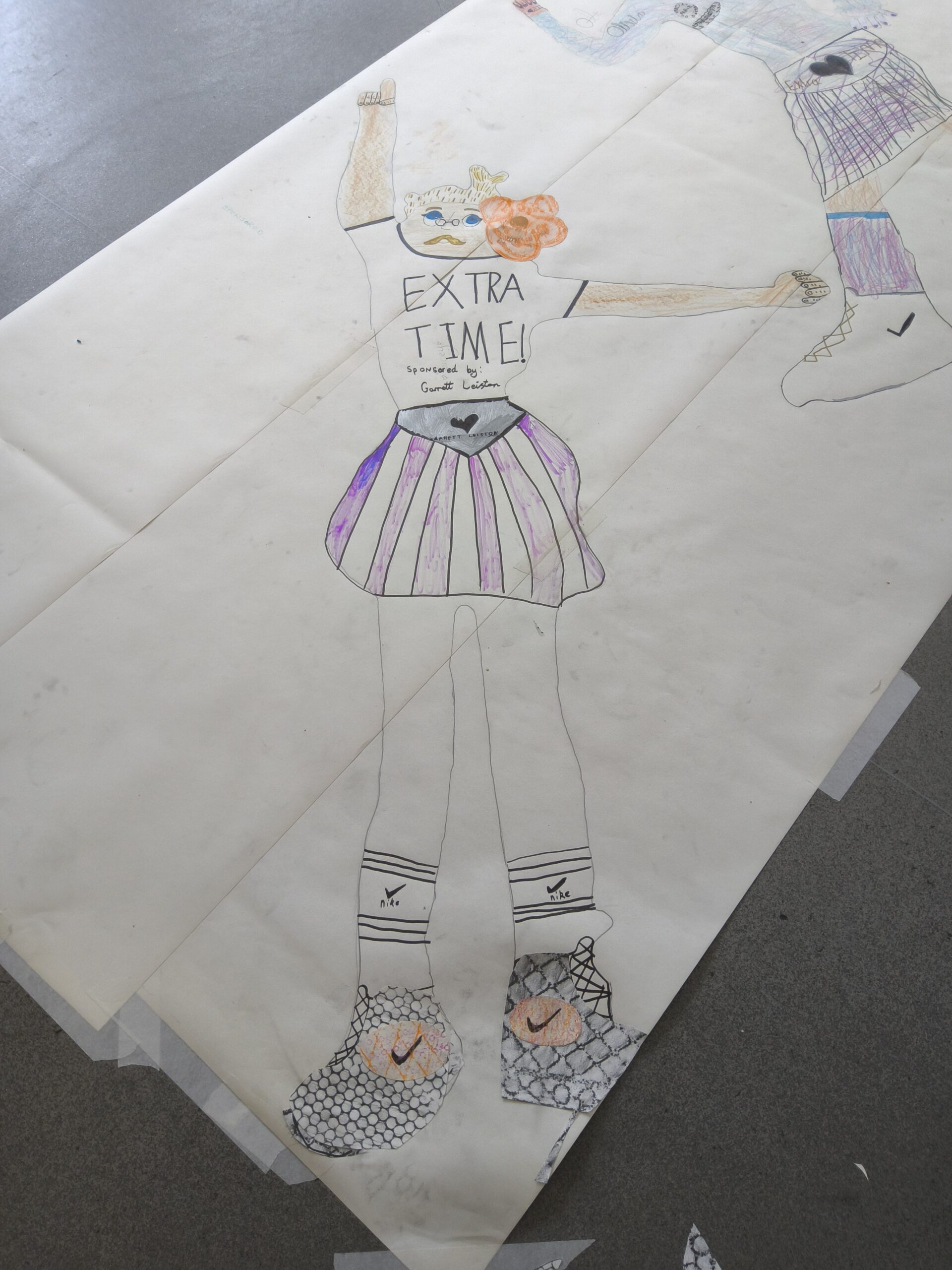 Extra Time a child sized drawing of a footballer on paper laid out on grey floor