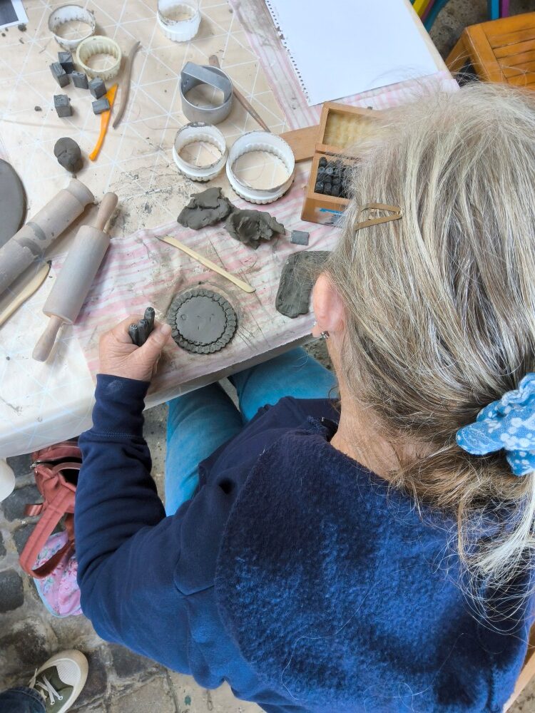 Overhead view of individual marking making on a clay disc