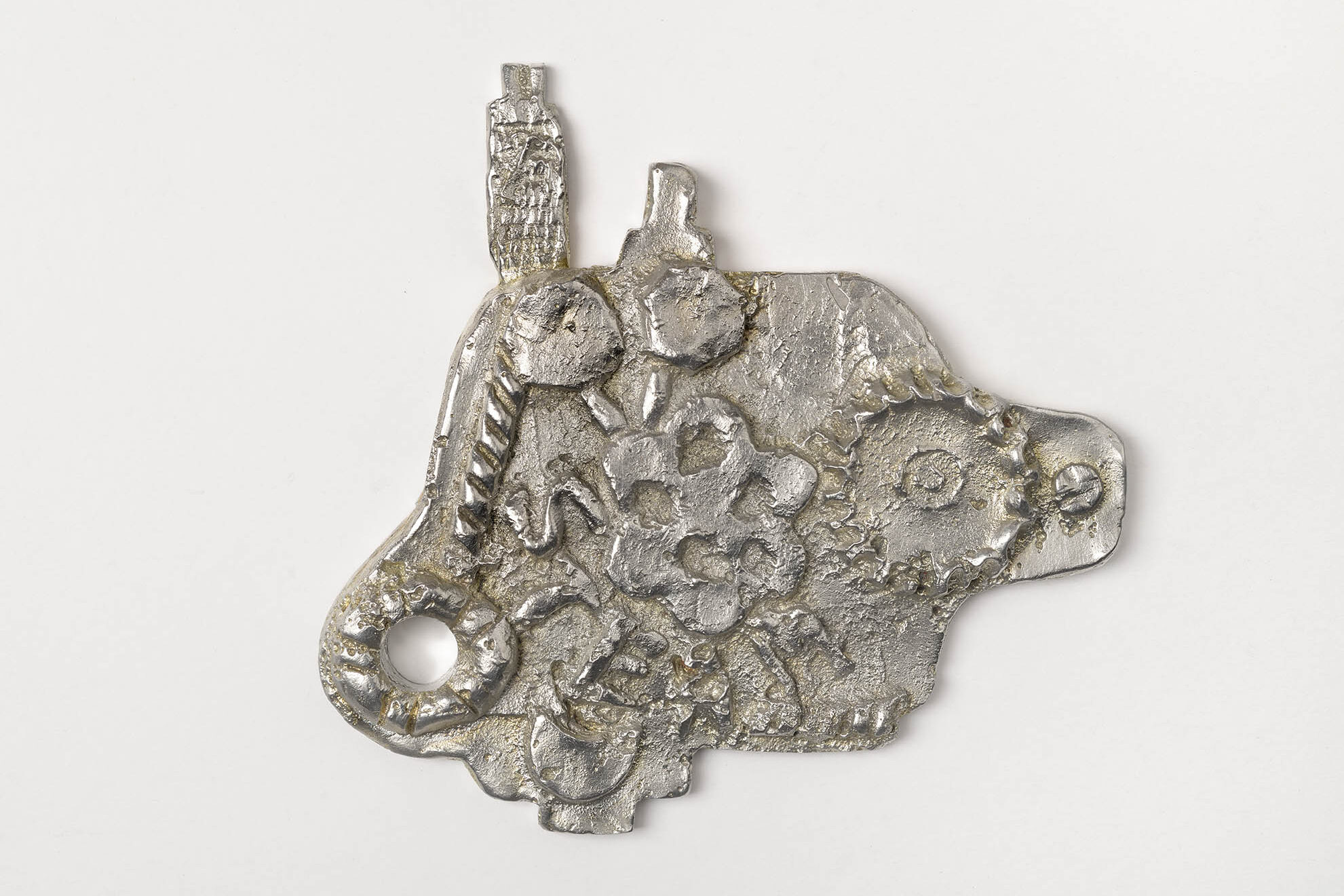 A pewter model, embellished with shapes referencing cogs and other machine parts and with word STEAM written on it