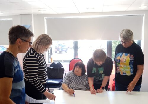 Group about to start drawing on a shared piece of paper.