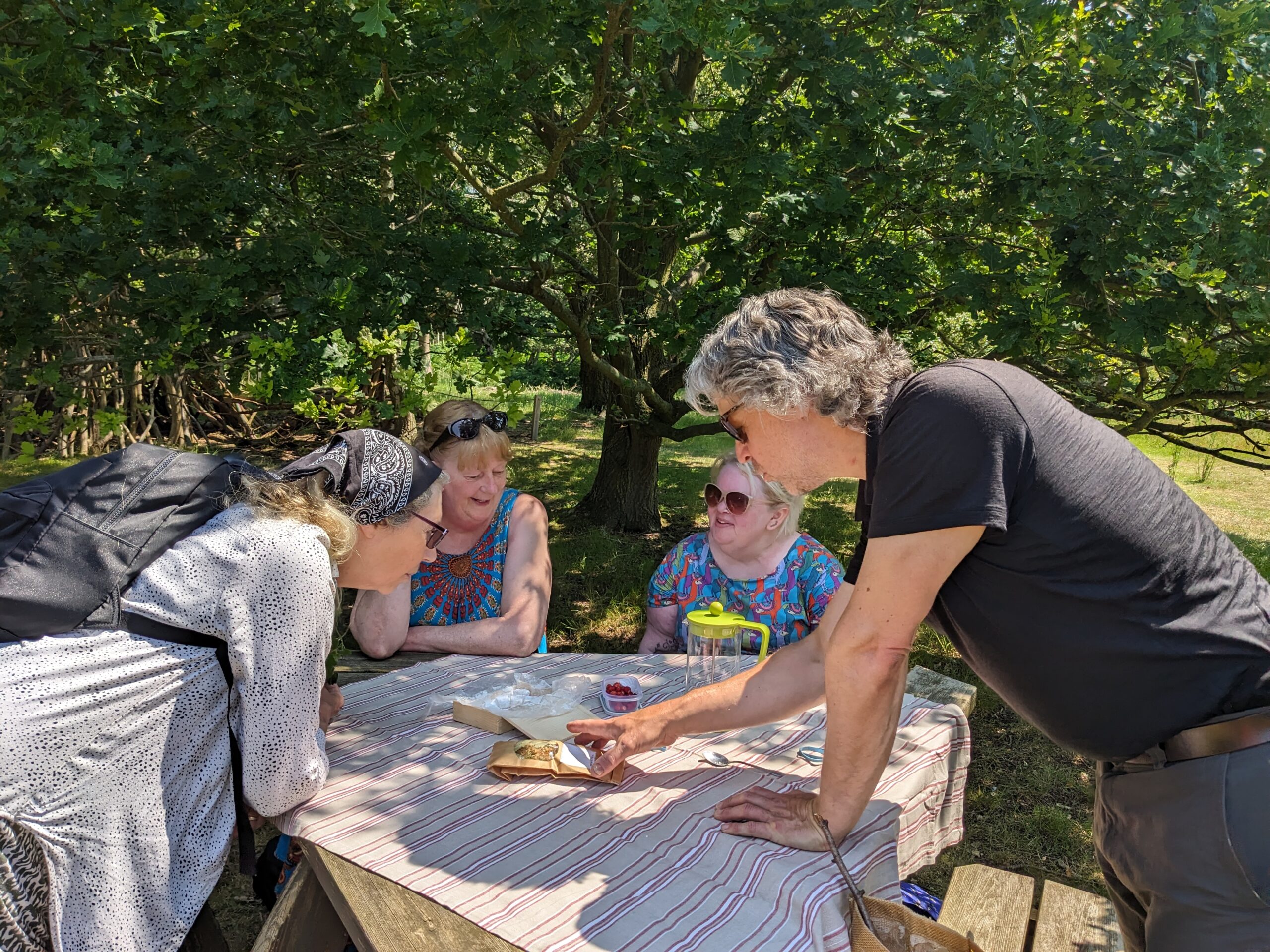 Jon Tyler with Nature Walk participants sitting around a table.