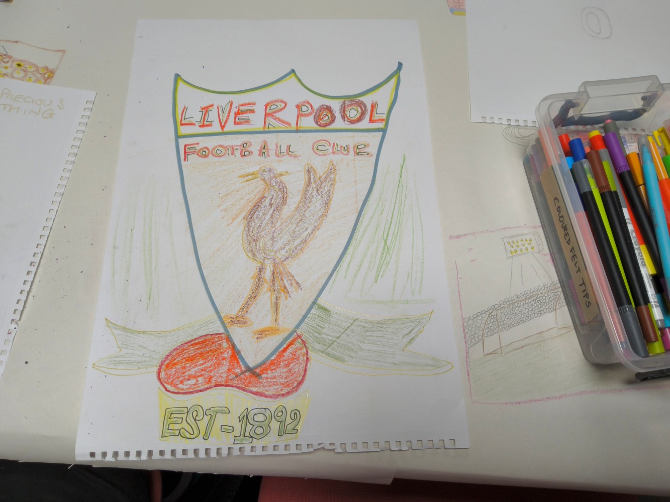 Liverpool Football Club est 1892. A colourful picture of the Club's emblem, alongside a box of coloured pens