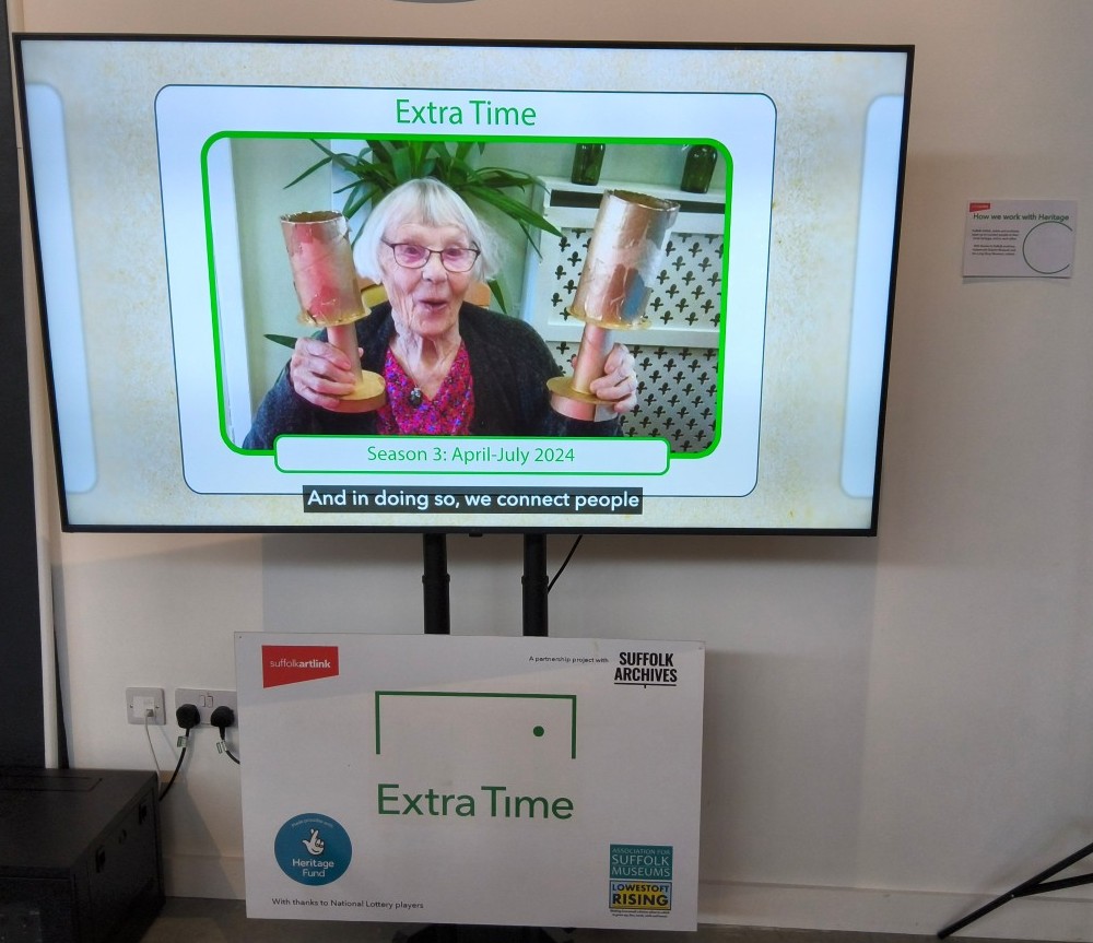 A large TV screen showing a lady holding up two trophies with caption readings Season 3: April-July 2024 And in doing so, we connect people