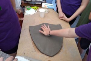 Clay disc being pushed into a clay shield