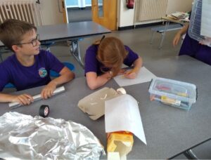 A pupil drawing on a piece of paper